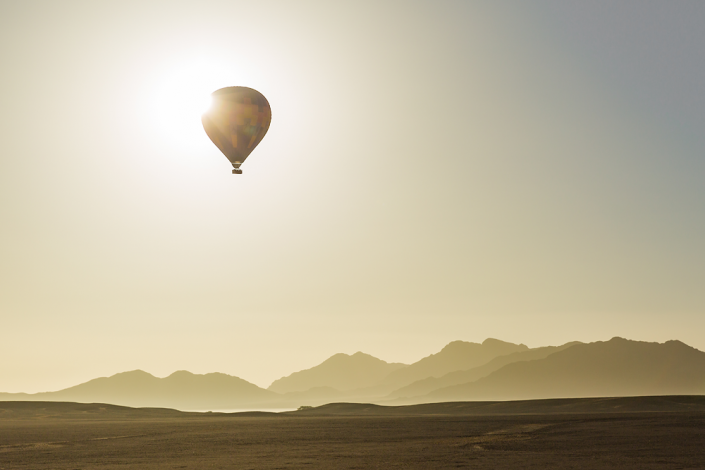 Heißluftballon verdeckt die Sonne über der Wüste